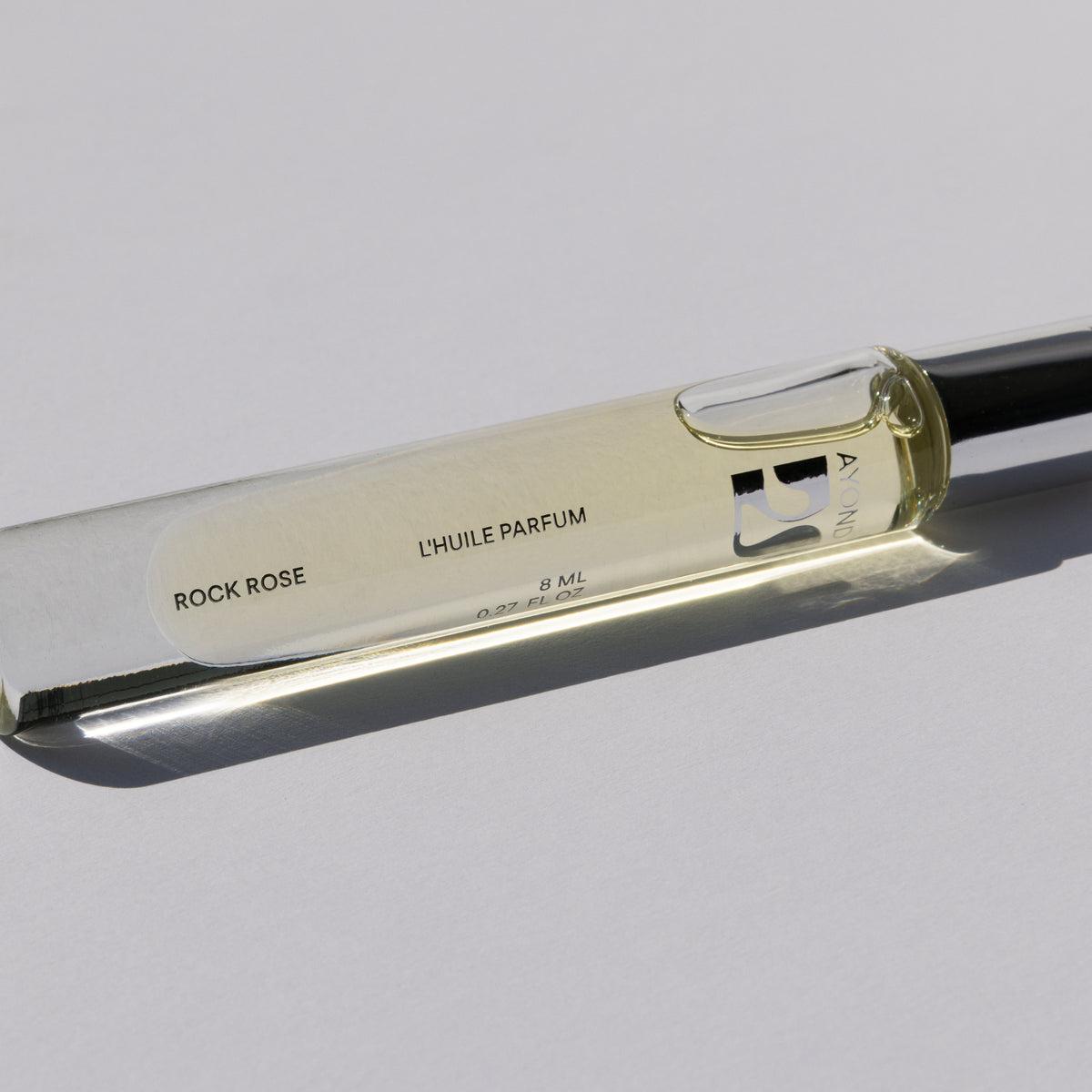 Rock Rose Perfume Oil rollerball lying on its side