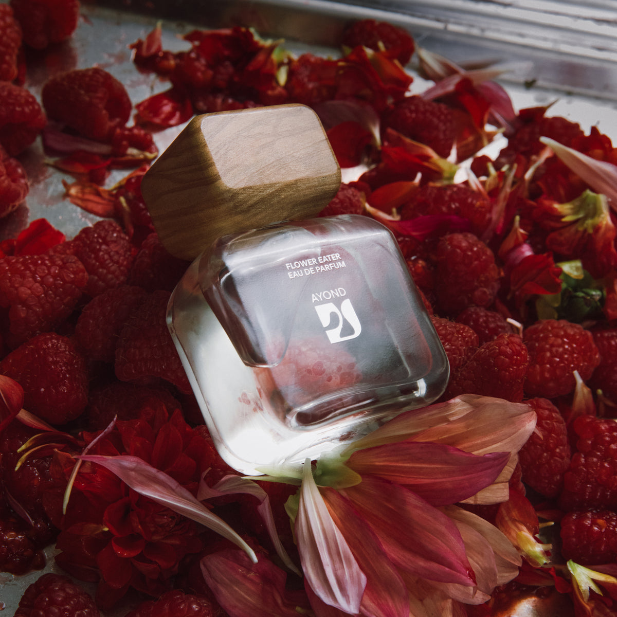 Flower Eater Eau de Parfum bottle on a bed of red berries and petals