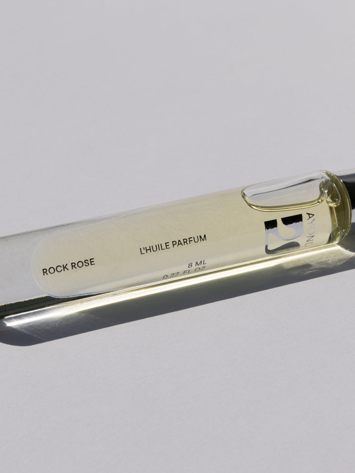 AYOND perfume oil rollerball lying on its side
