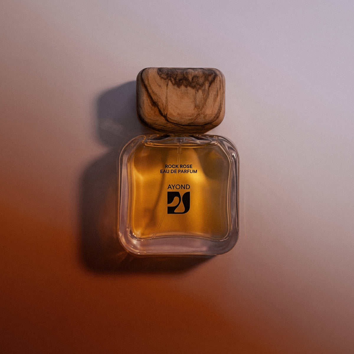 Rock Rose Eau de Parfum bottle on a warm terracotta background