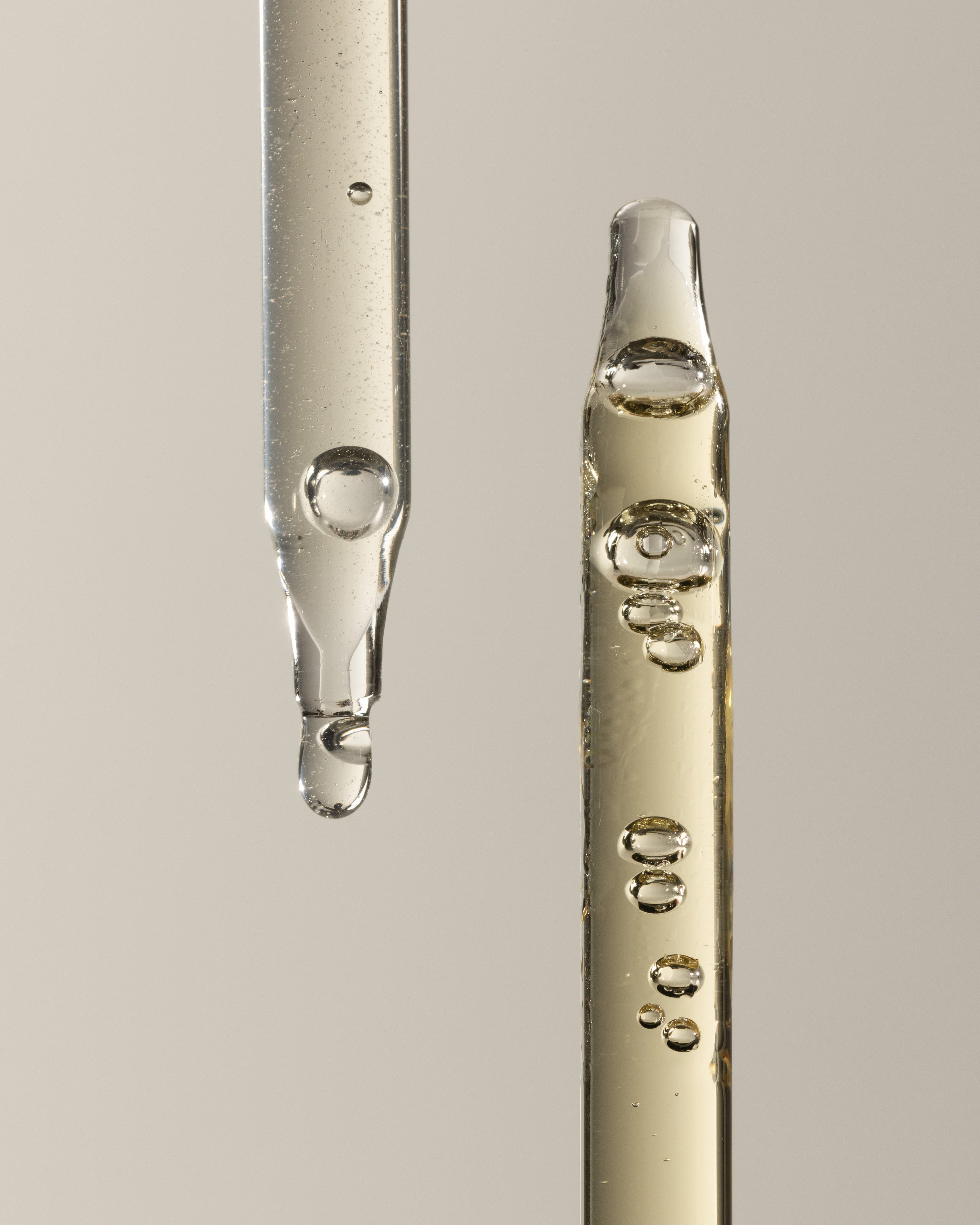 Two glass droppers of AYOND serum and oil